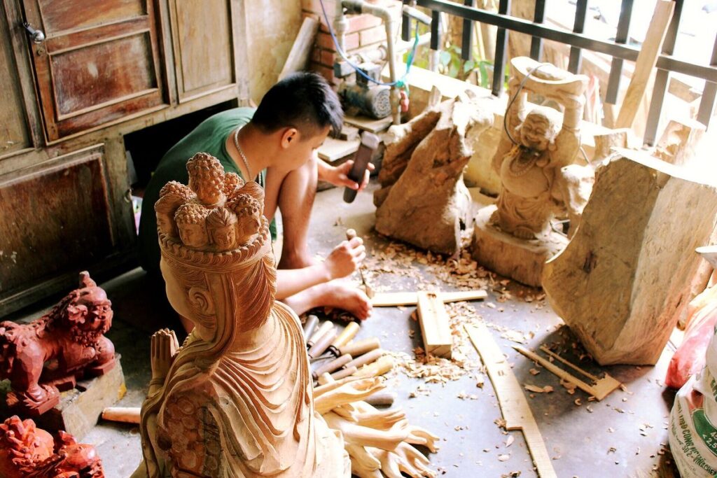 Wood artisan carving a traditional statue in An Nhon, Binh Dinh