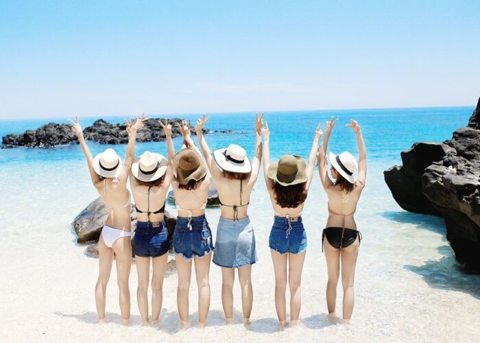 Travelers wearing swimwear on a sunny beach in Quy Nhon, Vietnam